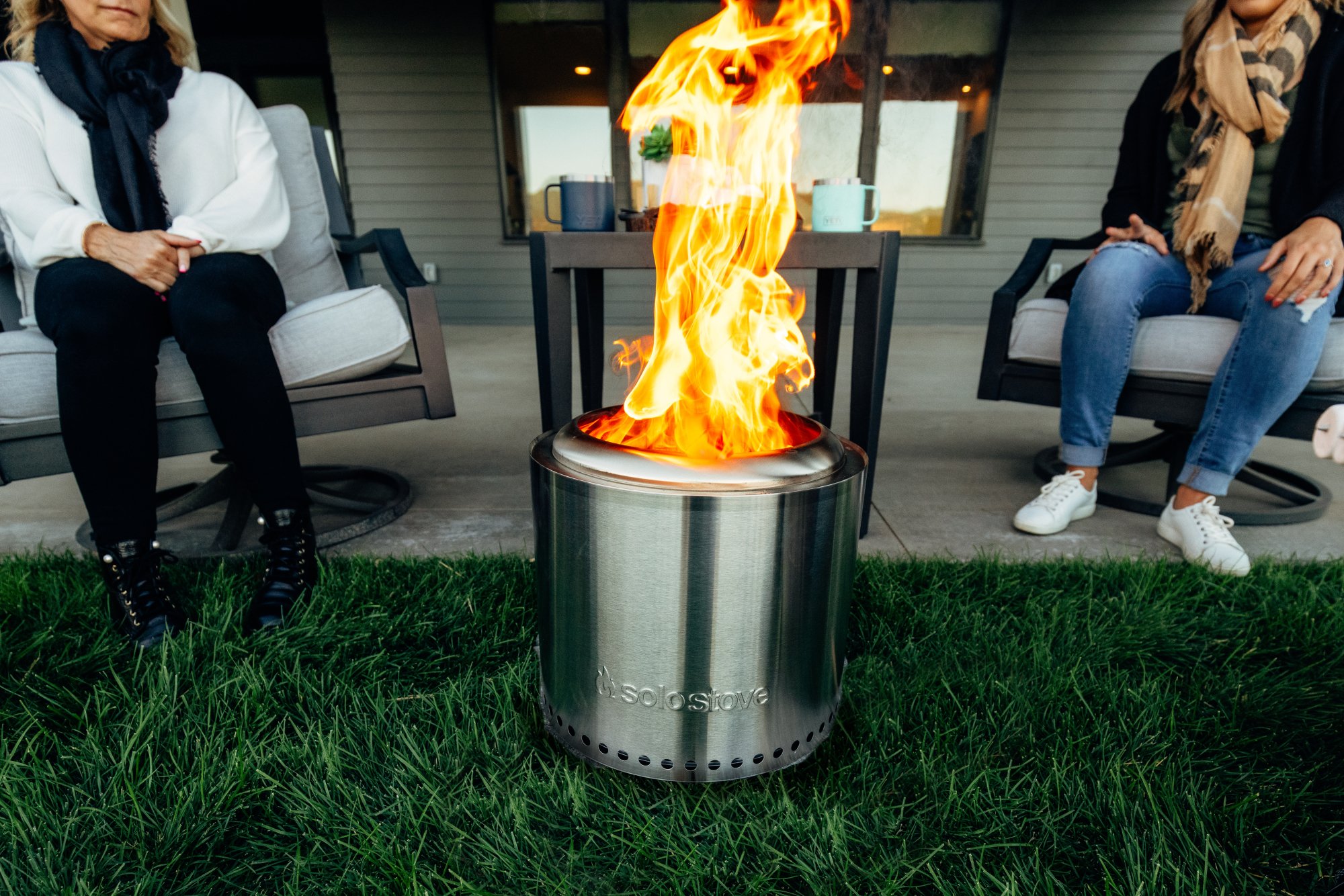 silver cylindrical fire pit with flames coming out the top