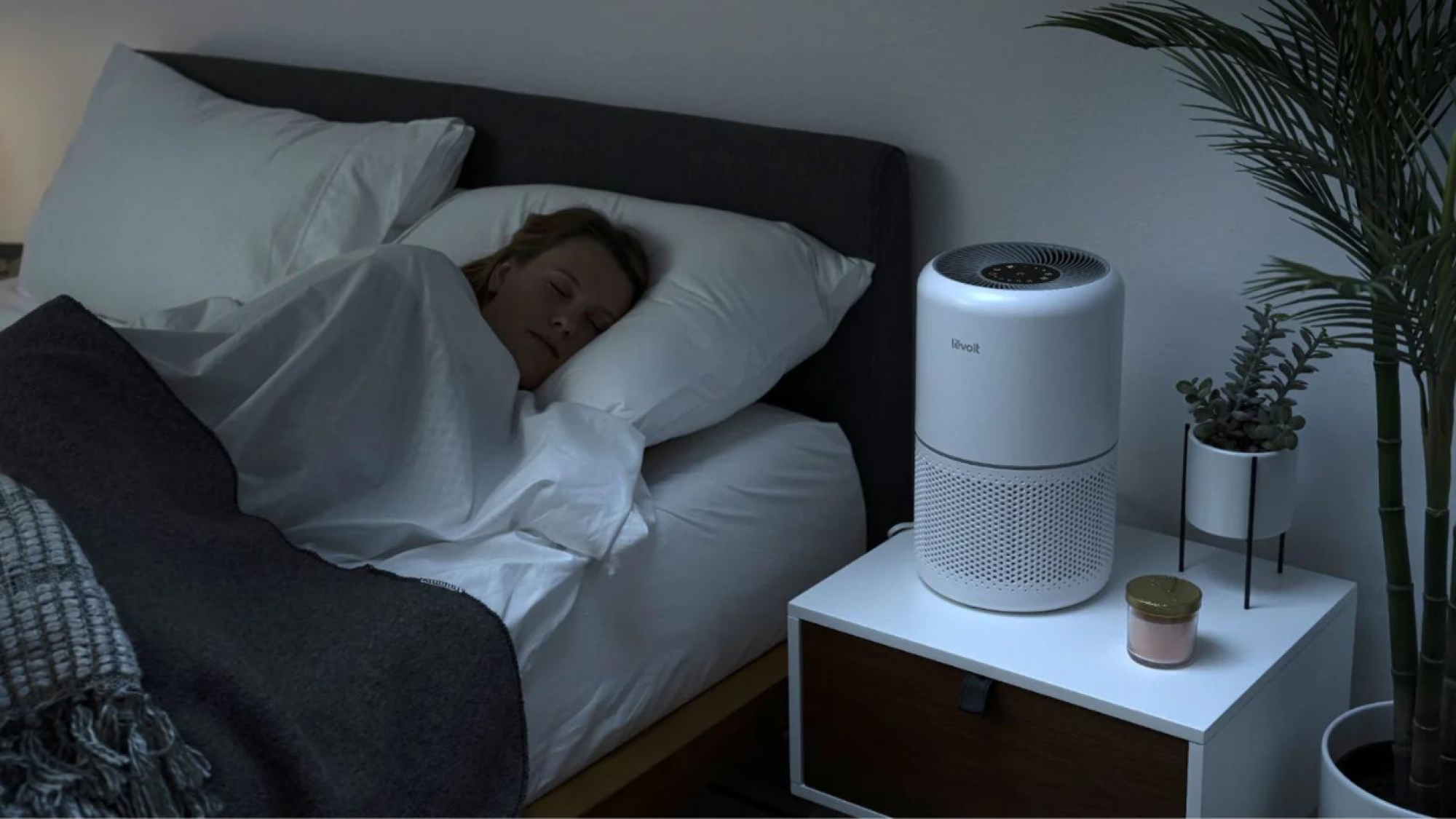 woman sleeping with air purifier on nightstand