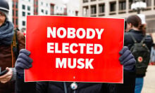 Someone holding a sign that says "NOBODY ELECTED MUSK" at an anti-DOGE protest