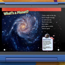 A blue children's tablet displays a page from an e-book titled "What's a Planet?". The page features a colorful image of a spiral galaxy, a short poem about planets, and a sidebar with definitions of space terms like "gas" and "star."