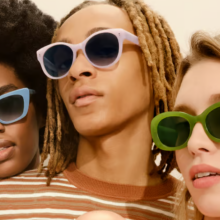 three women wearing sunglasses in light blue, light pink, and olive green