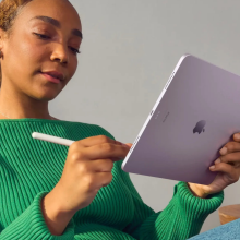 Person writing with Apple Pencil on purple iPad Air