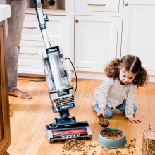 shark vacuum cleaning up dog food on hardwood floor 