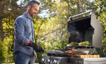 A man cooks out on a Weber grill