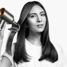 woman uses dyson supersonic with flyaway attachment on her hair