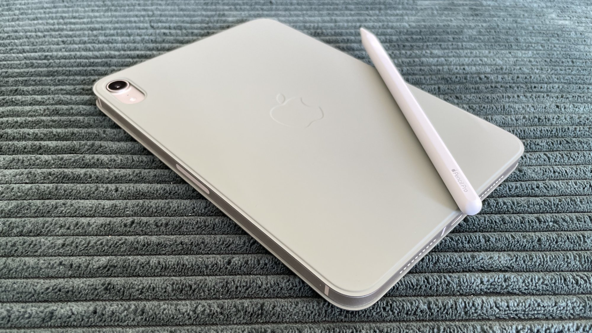 An Apple iPad mini 7 sitting on a soft surface.