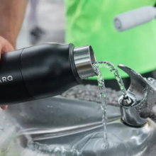 person filling up water bottle at drinking fountain