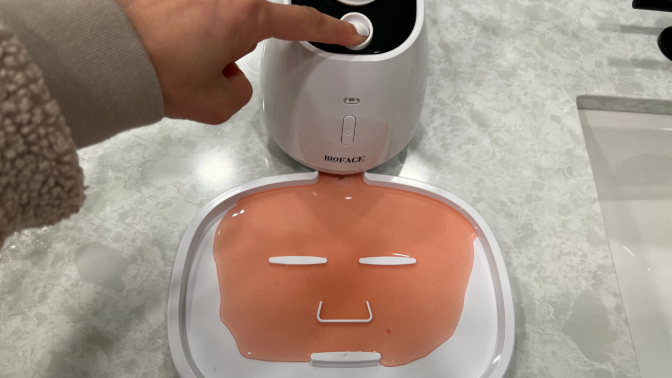 pink liquid coming out of machine forming into facial sheet mask