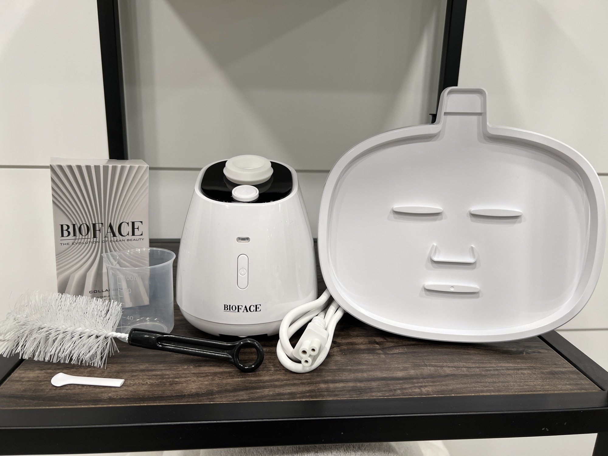 small white machine with face mask shaped tray