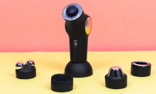 a small massage gun-like tool with an array of attachments