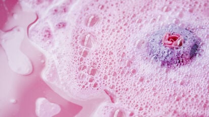 pink bubbly bath water with rose bath bomb