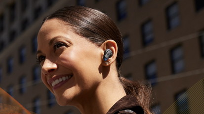 smiling woman with jbl earbuds in ear