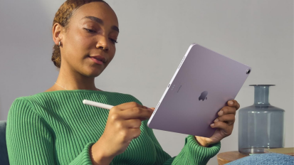 Person holding purple iPad Air and using Apple Pencil