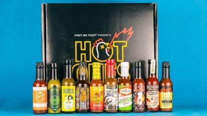 collection of hot sauces from "Hot Ones" show in decorative Heatonist box