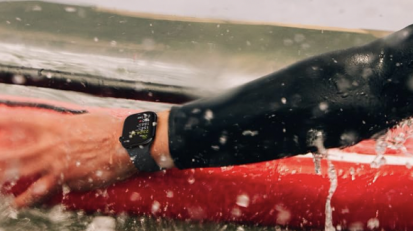 person wearing apple watch series 10 while on a red surfboard in the ocean