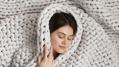 person wrapped in a gray bearaby weighted blanket