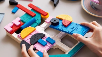 close-up of person completing lego abstract art model 