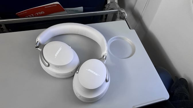 bose quietcomfort ultra headphones on airplane tray table