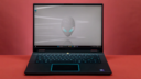 the alienware m16 r2 against a reddish-orange background