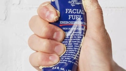 Close-up of a hand squeezing bottle of Kiehl's Facial Fuel scrub