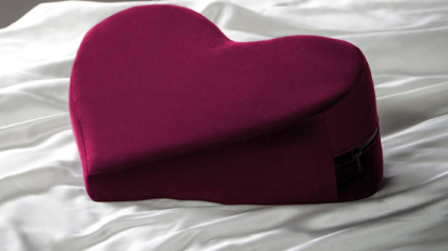 heart-shaped wedge pillow laying on bed