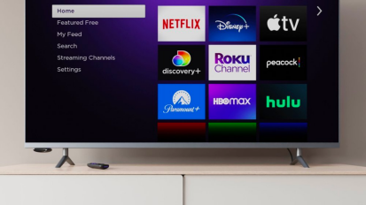 a roku express 4+ plus hooked up to a tv with its voice remote sitting on the console below