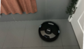 Shark robot vacuum cleaning tile floor by bathtub