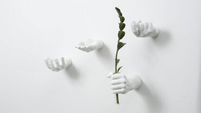 areaware hand-shaped wall hooks on white wall