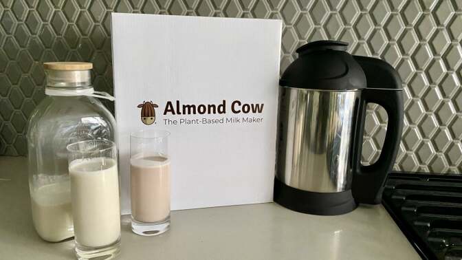 Almond cow machine next to cups of non-dairy milks