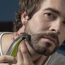 Person using a Philips Norelco OneBlade electric razor to shave.