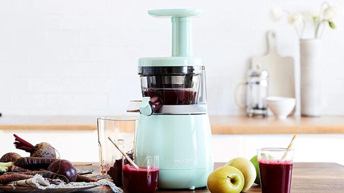 Mint colored juicer making a dark colored beet juice