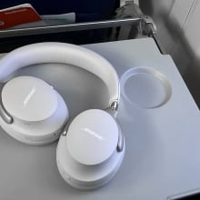 the bose quietcomfort ultra headphones on airplane tray table