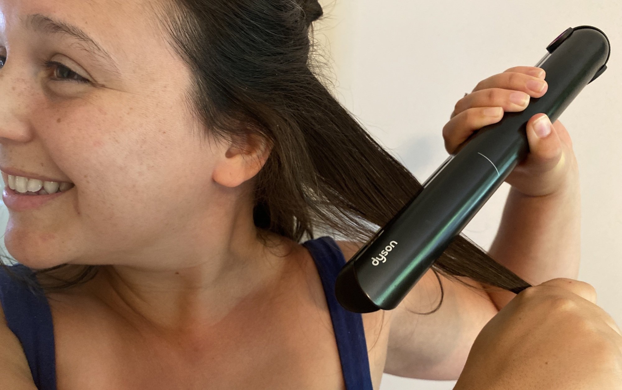 woman using the dyson corrale flat iron