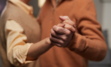 senior couple dancing while holding hands 