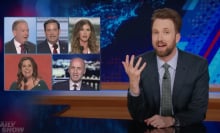 A man in a suit sits behind a talk show desk, gesturing at images of five other people in the top-left.