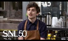 white man with unfurled hair wearing brown apron