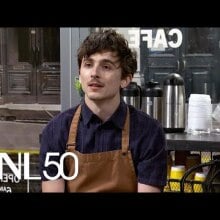 white man with unfurled hair wearing brown apron