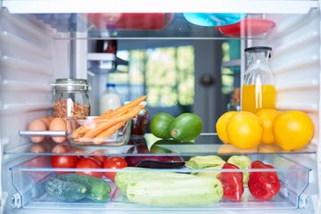 opened fridge from the inside full of vegetables, fruits and other groceries