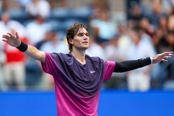 jack draper stretches his arms out and smiles as he celebrates winning a tennis match