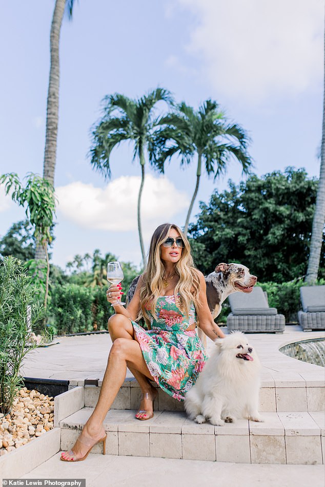 Uchitel relaxes by her pool with her two dogs by her side