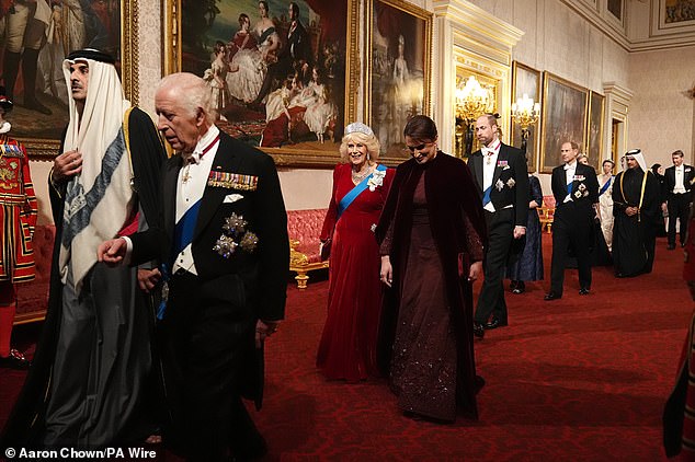 Prince William, who can be seen walking behind Queen Camilla (in red), was not joined by his wife Kate