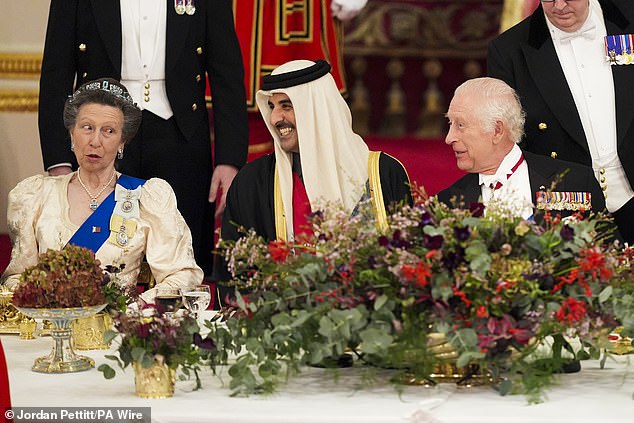 The Princess Royal photographed during a lighthearted moment with the Emir, as King Charles listened in