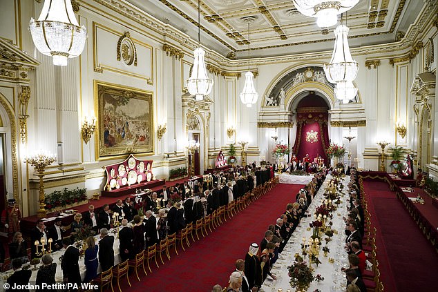 The palace ballroom was decorated with a riot of seasonal flowers and foliage in red, reflecting the Qatari flag, arranged in silver-gilt centrepieces taken from the Grand Service from Windsor Home Park and the Orchard Garden at the glasshouses in Windsor