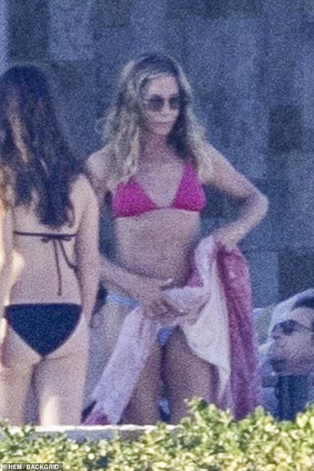 In photos obtained exclusively by DailyMail.com, the Friends star flaunted her figure in a pink-purple string bikini while hanging out at a luxe resort