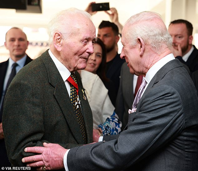 Charles smiled as he met 102-year-old D-Day veteran Eugeniusz Niedzielski (pictured left) at the centre