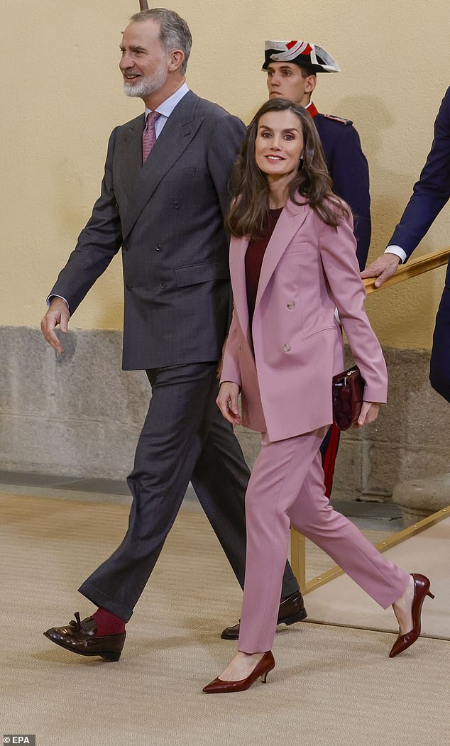 Felipe added pink and red tones to his outfit to match his wife's pink suit and crimson accessories