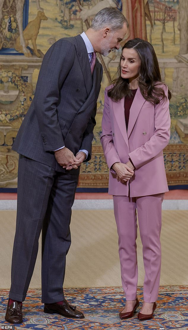 Letizia listened intently as her husband Felipe whispered some words into her ear at the meeting