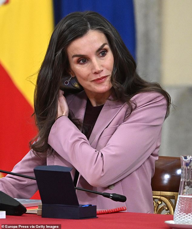 The royal mother-of-two is seen briefly adjusting her hair during the meeting in Madrid on Wednesday