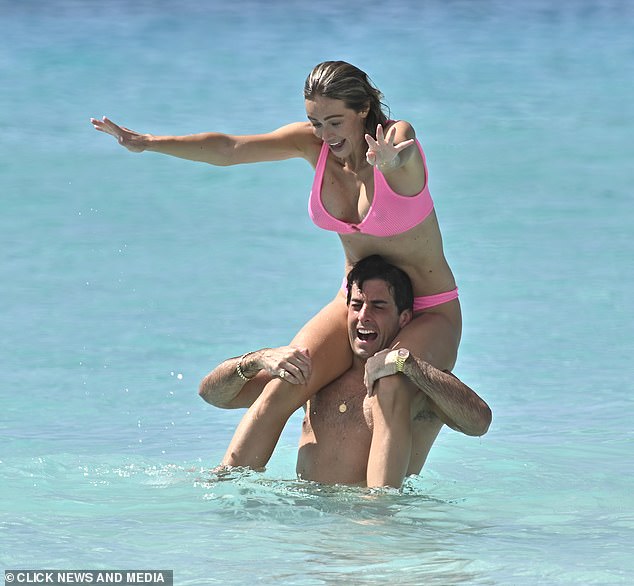 Nicoline almost topples into the water after climbing onto James' shoulders