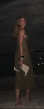 Another part of the clip showed Friday back at the beach at night in a chic green maxi dress as she wandered bare foot